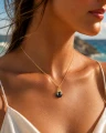 Pozłacany naszyjnik ośmiornica z czarną perłą Swarovski na modelce.png