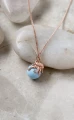 Naszyjnik ośmiornica z błękitną perłą Swarovski w różowym złocie na jasnych kamieniach.png