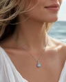 Srebrny naszyjnik ośmiornica z błękitną perłą Swarovski pastel blue na modelce.png