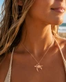 Naszyjnik ŻÓŁW MORSKI w różowym złocie na modelce, letnia plażowa stylizacja.png