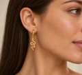 Kolczyk WĄŻ pozłacany 24K złotem na uchu modelki – wisząca zawieszka węża.png