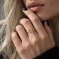 Regulowany pierścionek z wężem pozłacany 24K złotem na dłoni blondynki – biżuteria z motywem węża.png